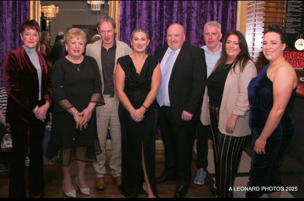 Sinead Kelly in a long black dress with Galway Camogie board members.